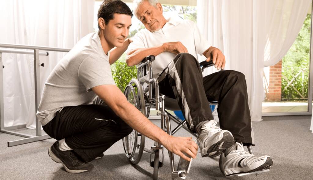 Junger Mann hilft Senior mit Rollstuhl